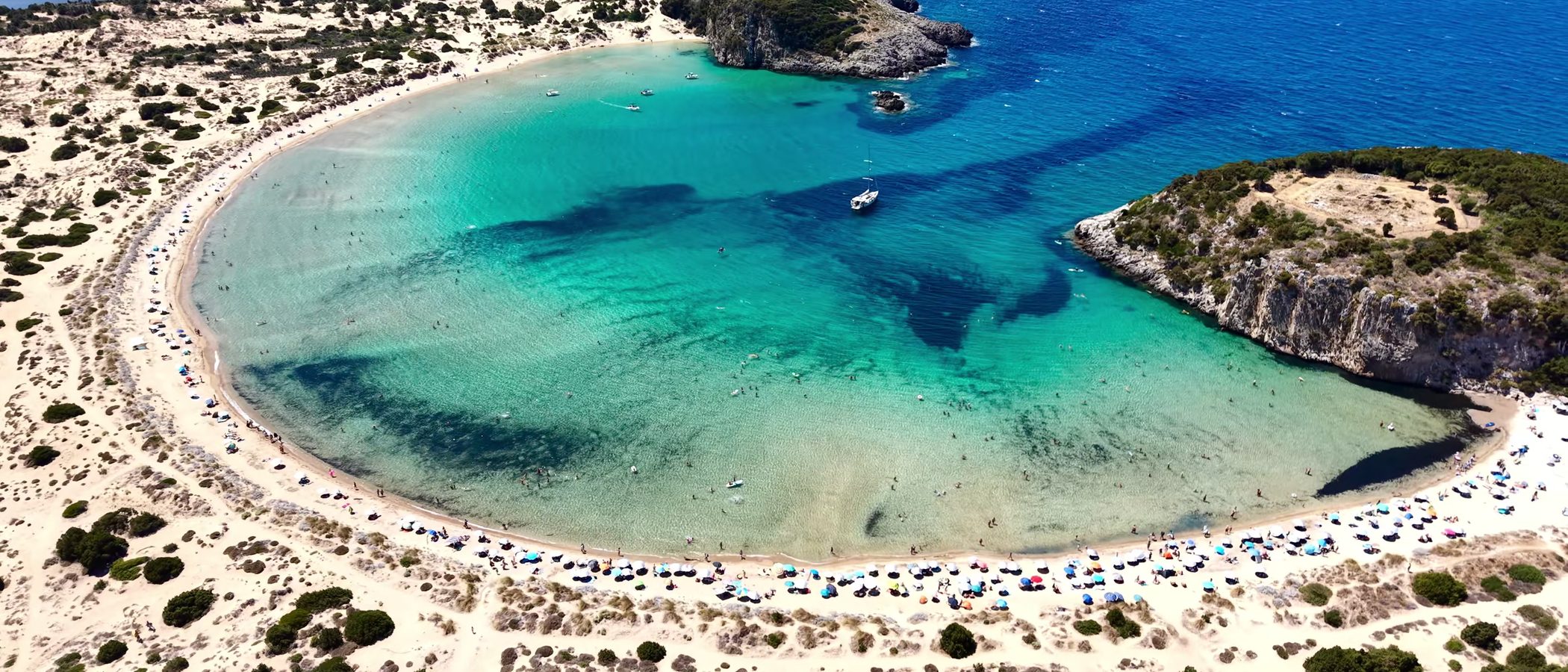 Bahía en forma de omega con arena clara y agua turquesa