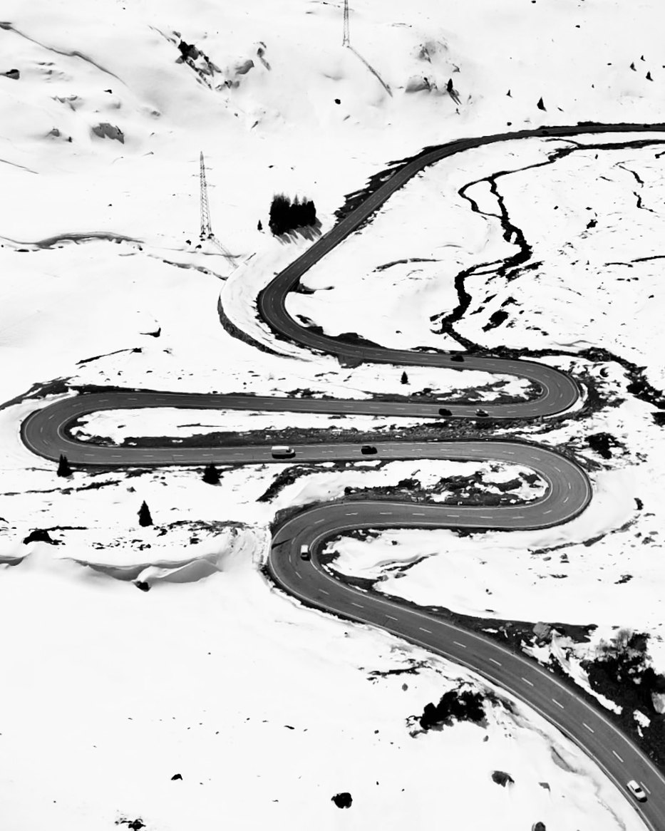 Curvas de un puerto alpino sobre la nieve, en blanco y negro