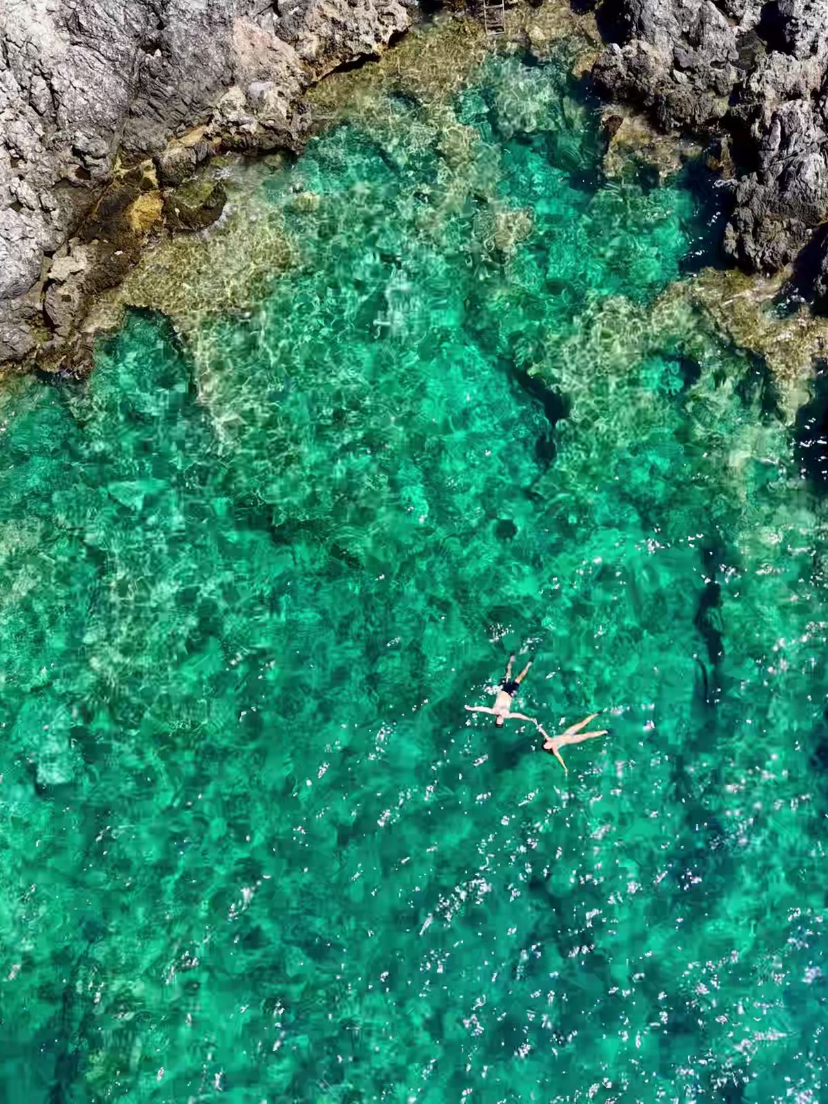 Lámina: agua turquesa y roca vistas desde el cenit